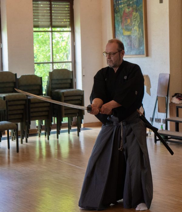 Iaido man in a black robe holding a sword