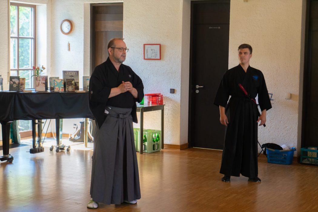 two men in black robes standing in a room